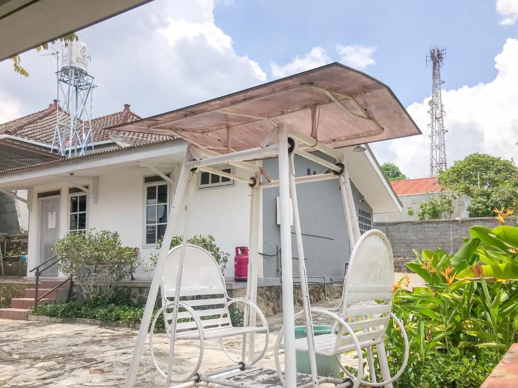 a group of chairs sitting in front of a house at Villa Bunga Guest House RedPartner in Malang