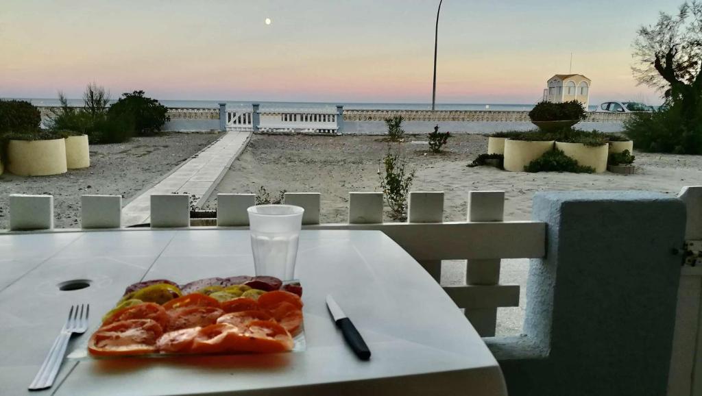 - une assiette de pizza sur une table avec vue sur la plage dans l'établissement Appartement 2 pièces PORT LA NOUVELLE PN430-027, à Port-la-Nouvelle
