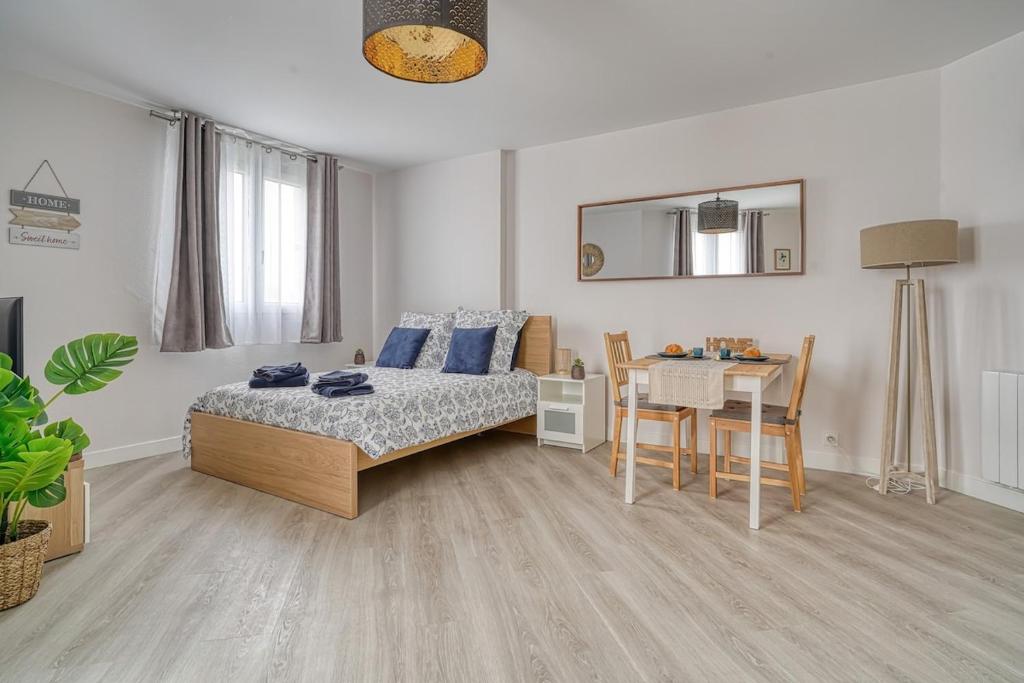 une chambre avec un lit et une table et une salle à manger dans l'établissement Logement Jules, Évry-Courcouronnes