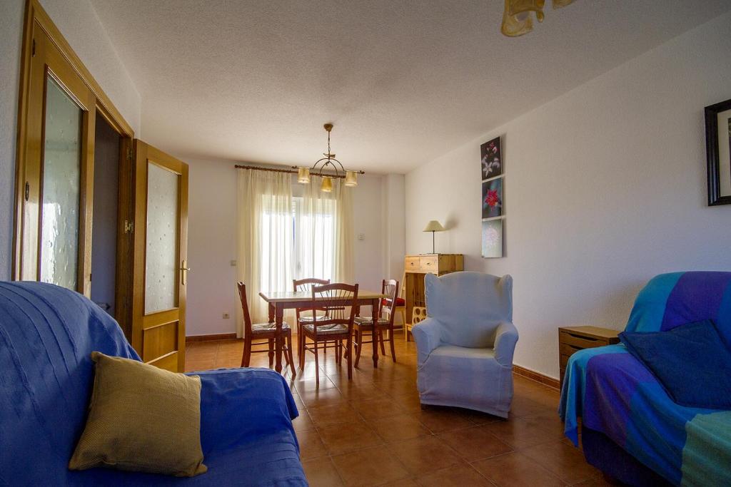 un salon avec un canapé, une table et des chaises dans l'établissement AT Las Viñuelas 17, à Burgohondo