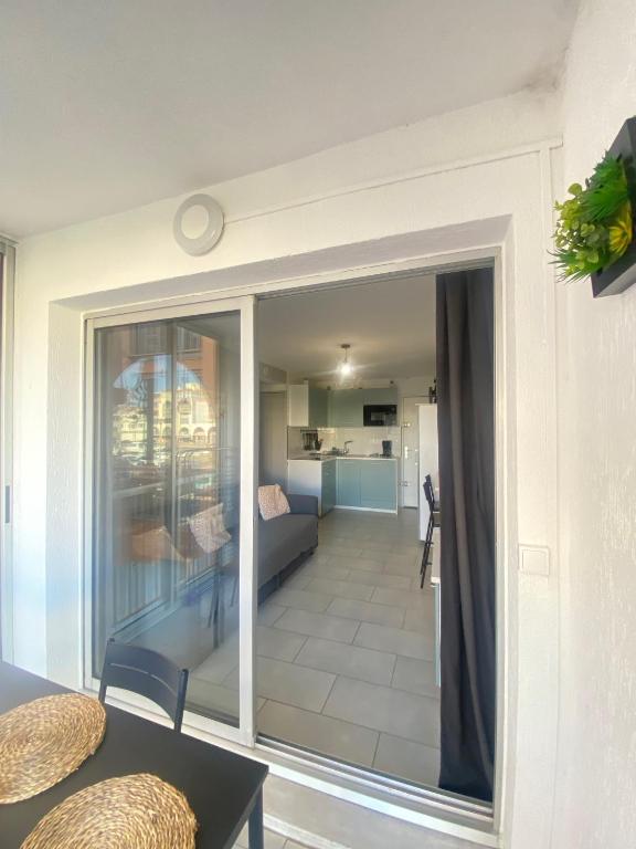 une chambre avec une porte coulissante en verre et un salon dans l'établissement Charmant T2 à 200m plage, à Sète