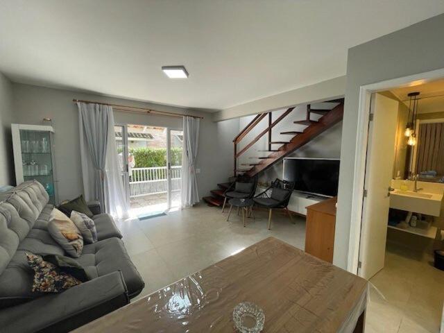 a living room with a couch and a table at Beautiful Casa em Riviera in Bertioga