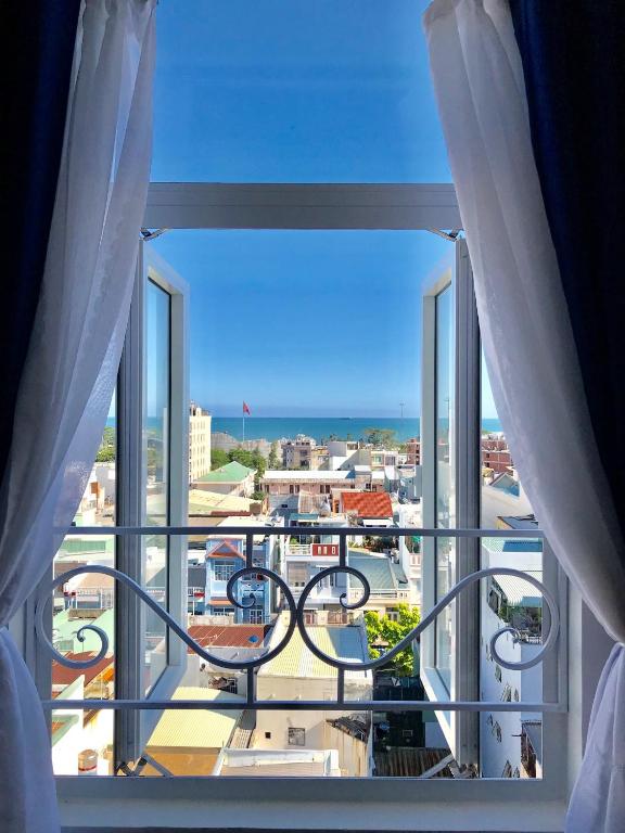 a room with a view of a city from a window at HaTa Hotel in Quy Nhon