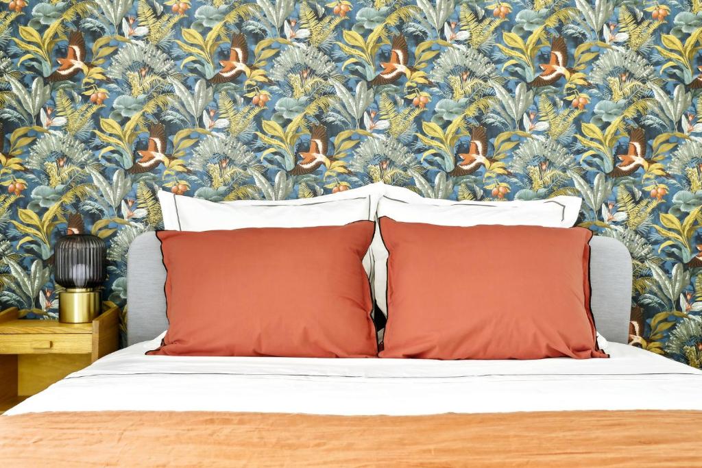 - un lit avec deux oreillers et un papier peint à fleurs dans l'établissement Luxury suite near Eiffel Tower, à Paris