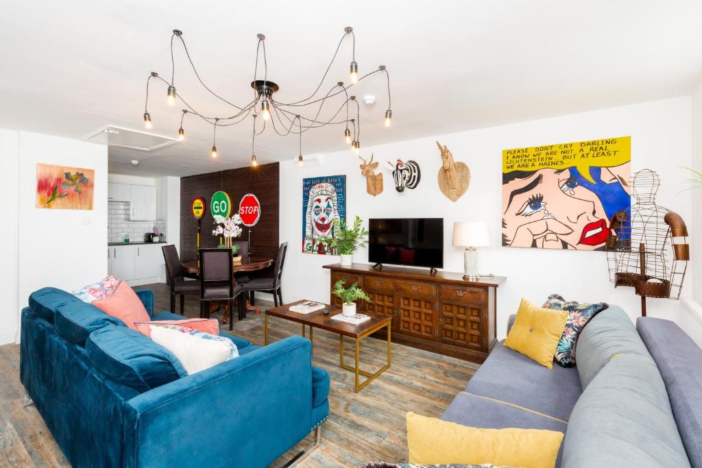 a living room with two blue couches and a tv at Printworks Building City Centre Penthouse 5 Bedrooms Sleeps 14 in Gloucester