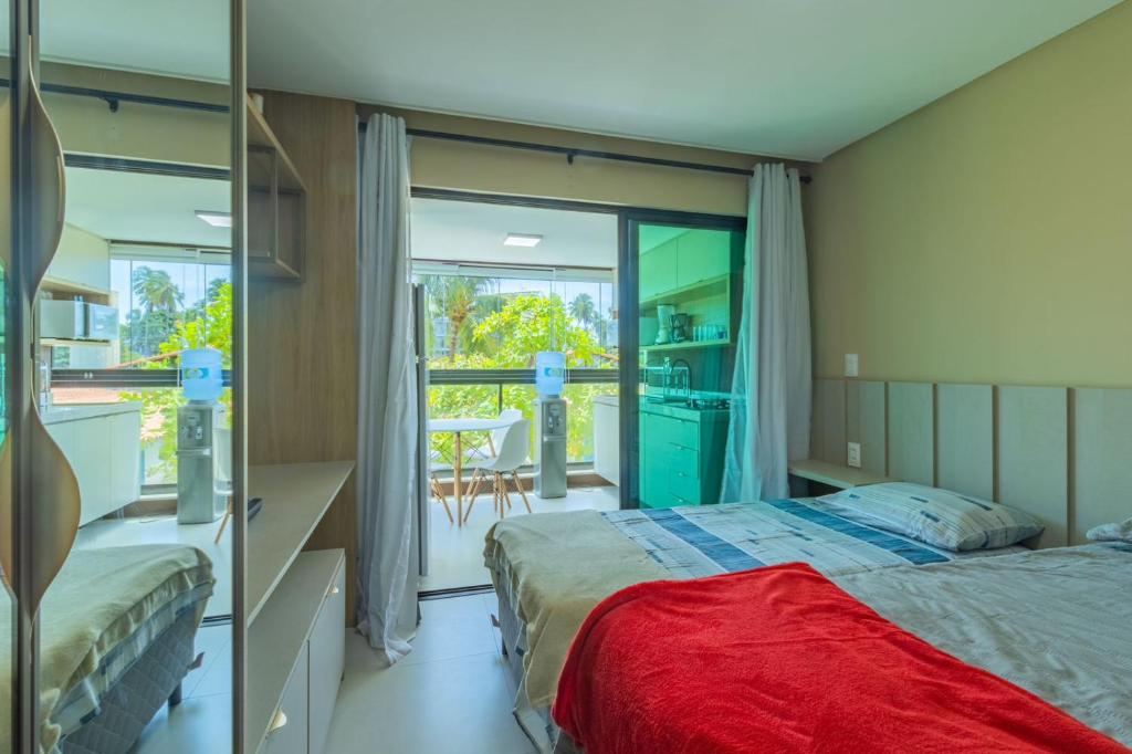 a bedroom with two beds and a balcony at Rooftop Tamandaré - apto 106 in Tamandaré