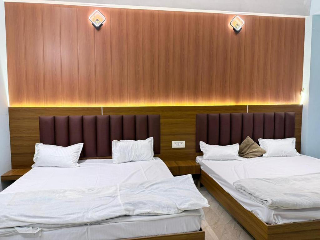 two beds are in a room with a wall at Maa durga home stay in Faizābād