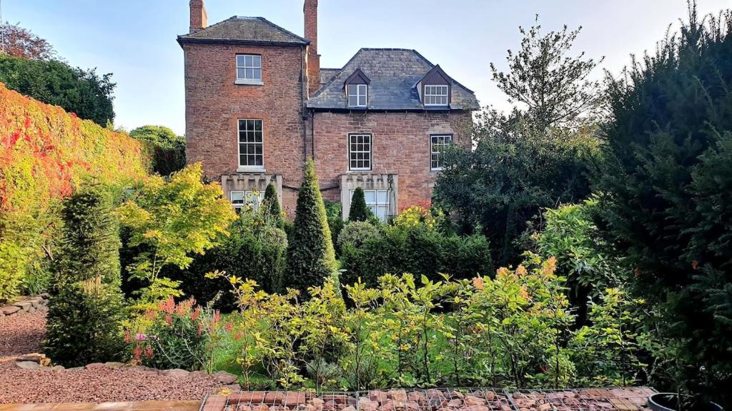 an old brick house in the middle of a garden at Clairville Apartment - Garden Terrace, Central Ross-on-Wye in Ross on Wye