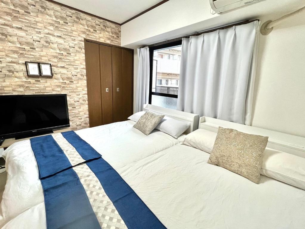 een slaapkamer met een groot bed en een tv bij 大国町駅徒歩3分 なんば駅1駅 最大4名 ロイヤル507 in Osaka