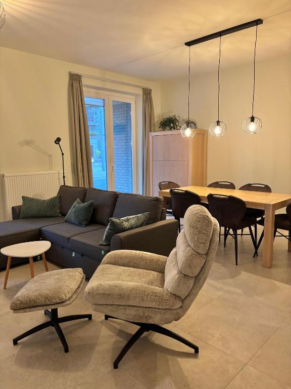 a living room with a couch and a table at Ruytingen Modern Seaside Suite in Koksijde