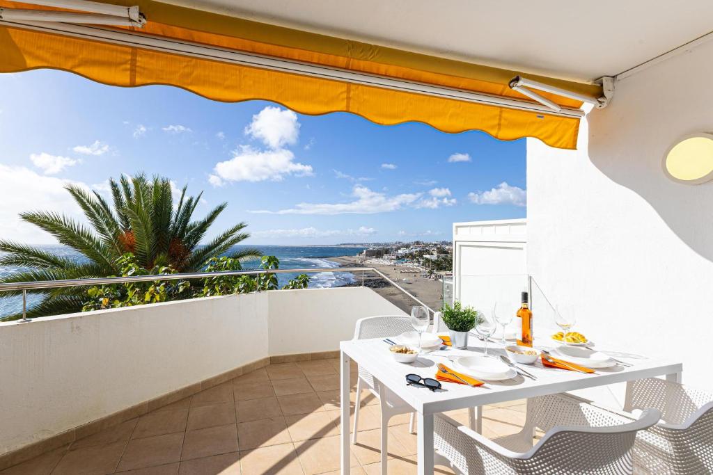 a white table and chairs on a balcony with a view of the ocean at Nueva S 523 by VillaGranCanaria in San Agustin