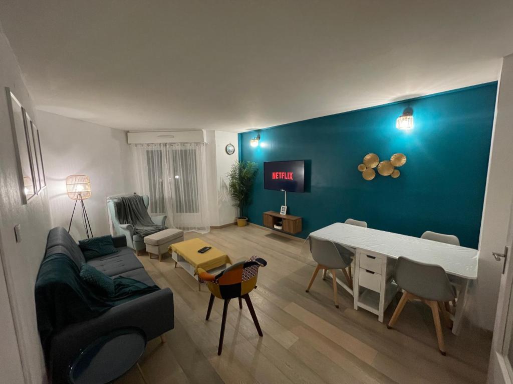 un salon avec un canapé et une table dans l'établissement Appartement tout confort à 30 min de Paris, à Cergy