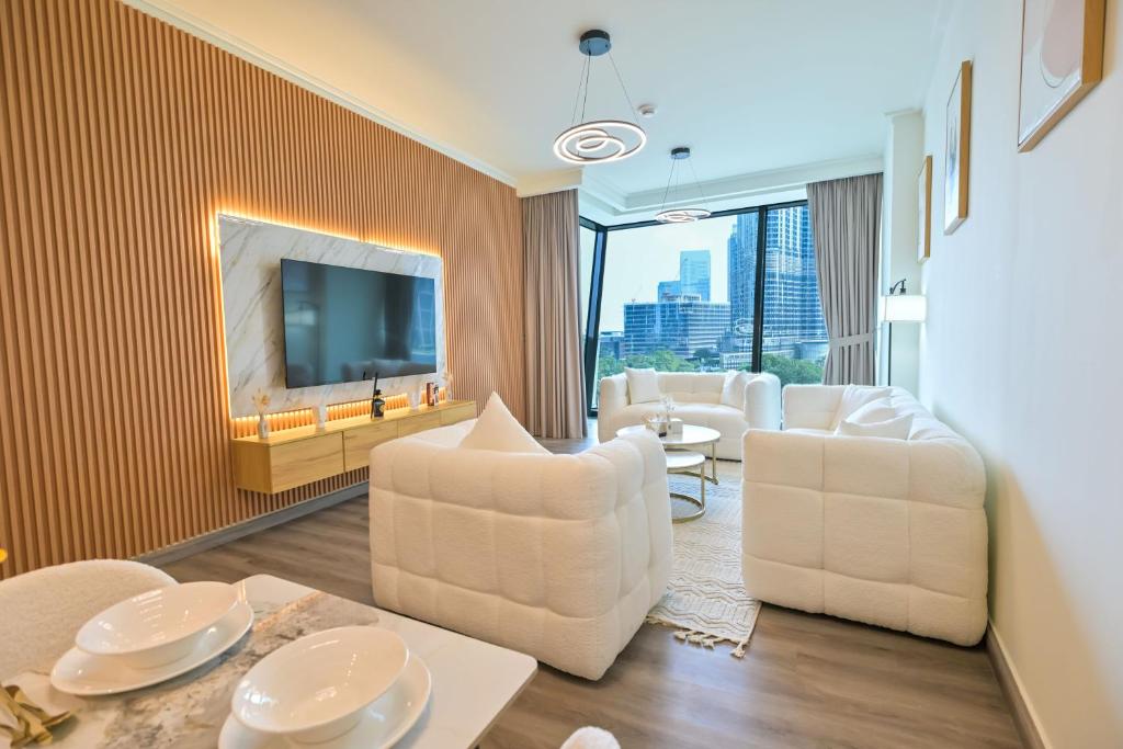 un soggiorno con mobili bianchi e una TV di Burj Vista 2BR Luxurious Apartment with Direct Access to Dubai Mall a Dubai