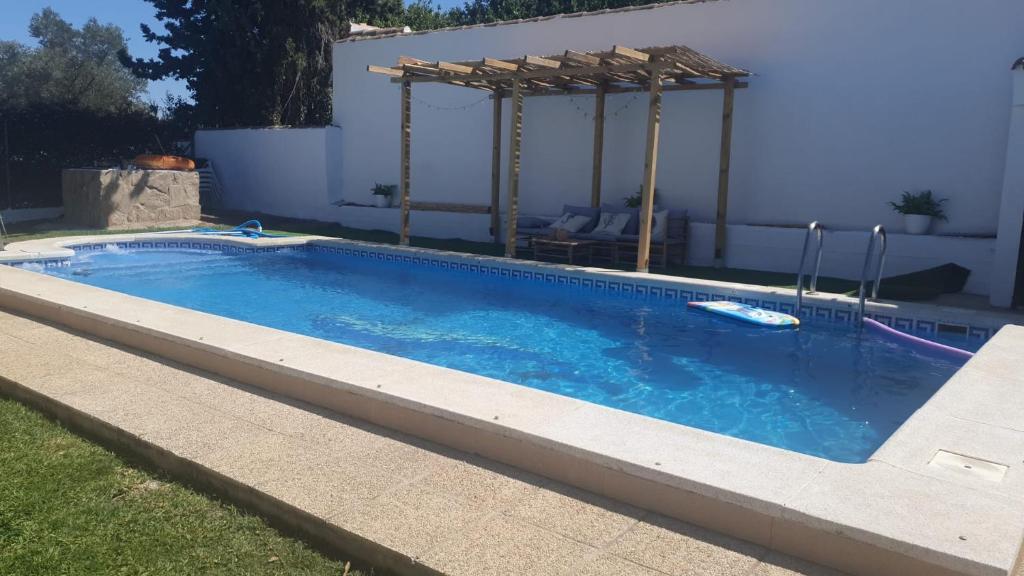 a swimming pool in a backyard with a pergola at Casa El Veranito in Chiclana de la Frontera