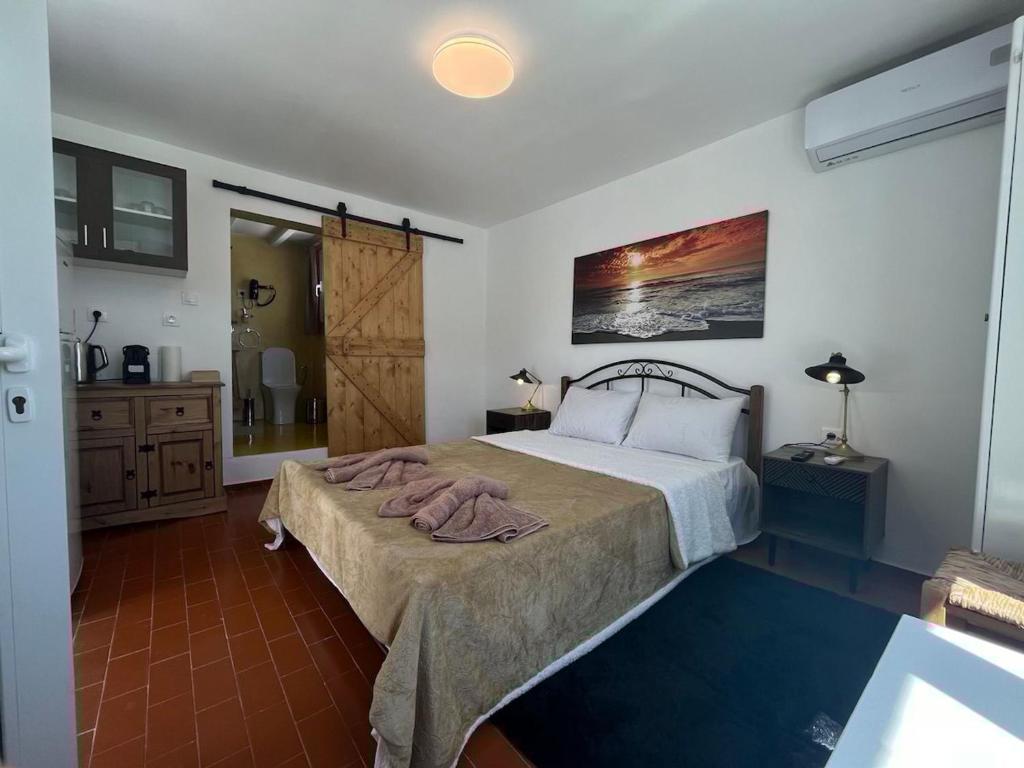 a bedroom with a large bed and a bathroom at Stephany's Skyline Studio in Parikia