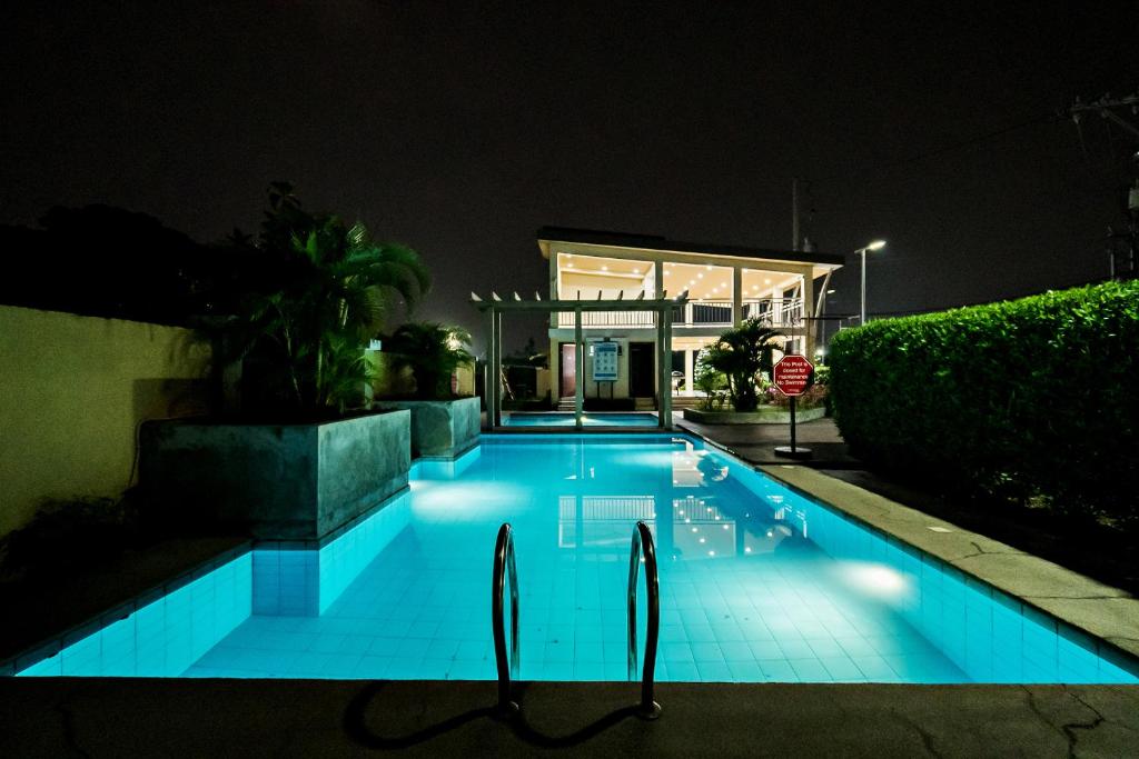 a swimming pool lit up at night at Kral Suite in Las Piñas in Manila