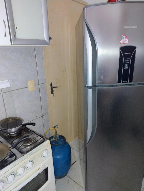 eine Küche mit einem Edelstahlkühlschrank und einem Herd in der Unterkunft Flat do Rafa in Caucaia