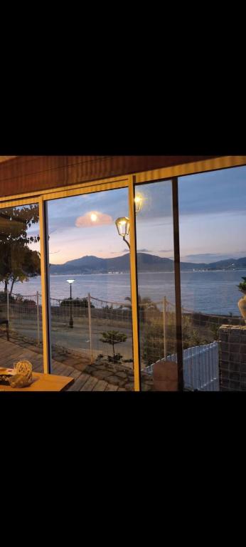 - une vue sur l'océan depuis une fenêtre en verre dans l'établissement CHALET de la plage, à Porticcio