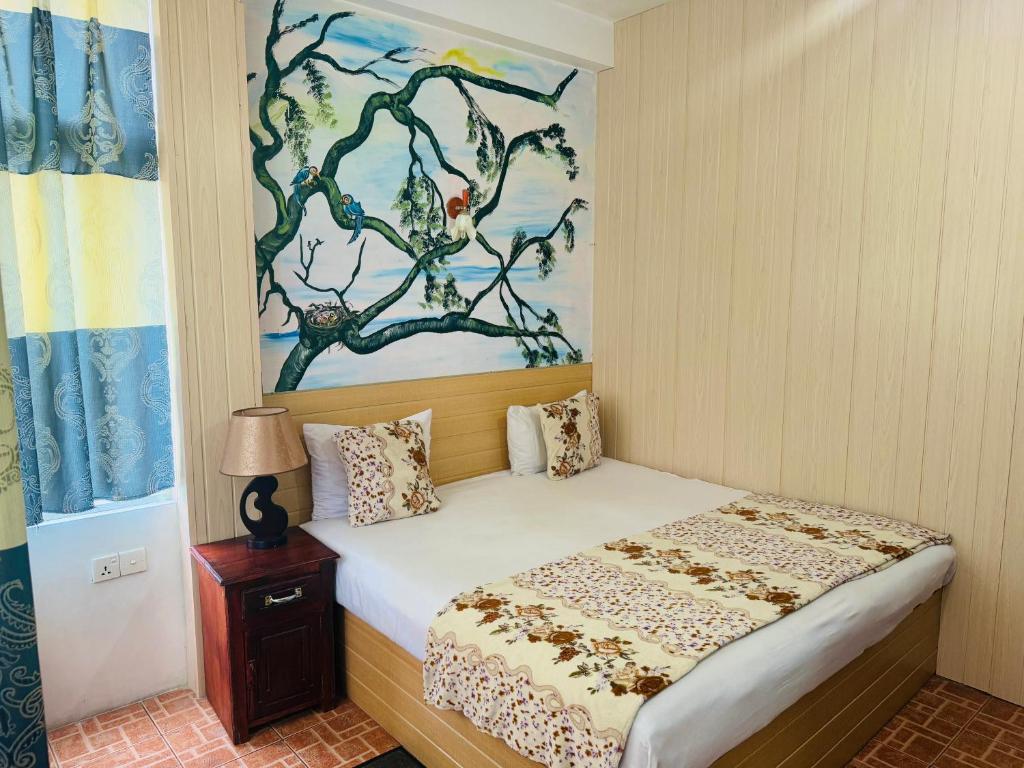 een slaapkamer met een bed met een schilderij aan de muur bij Siumi Rest in Nallathanniya
