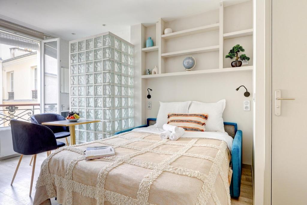 une chambre avec un lit, une table et des chaises dans l'établissement BnBNook - Studio - Eiffel Tower & Les Invalides, à Paris