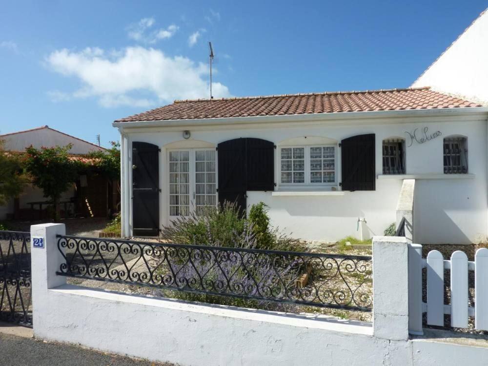 une maison blanche avec une clôture devant dans l'établissement Charmante maison vendéenne avec jardin et océan à 200m, à Saint-Hilaire-de-Riez