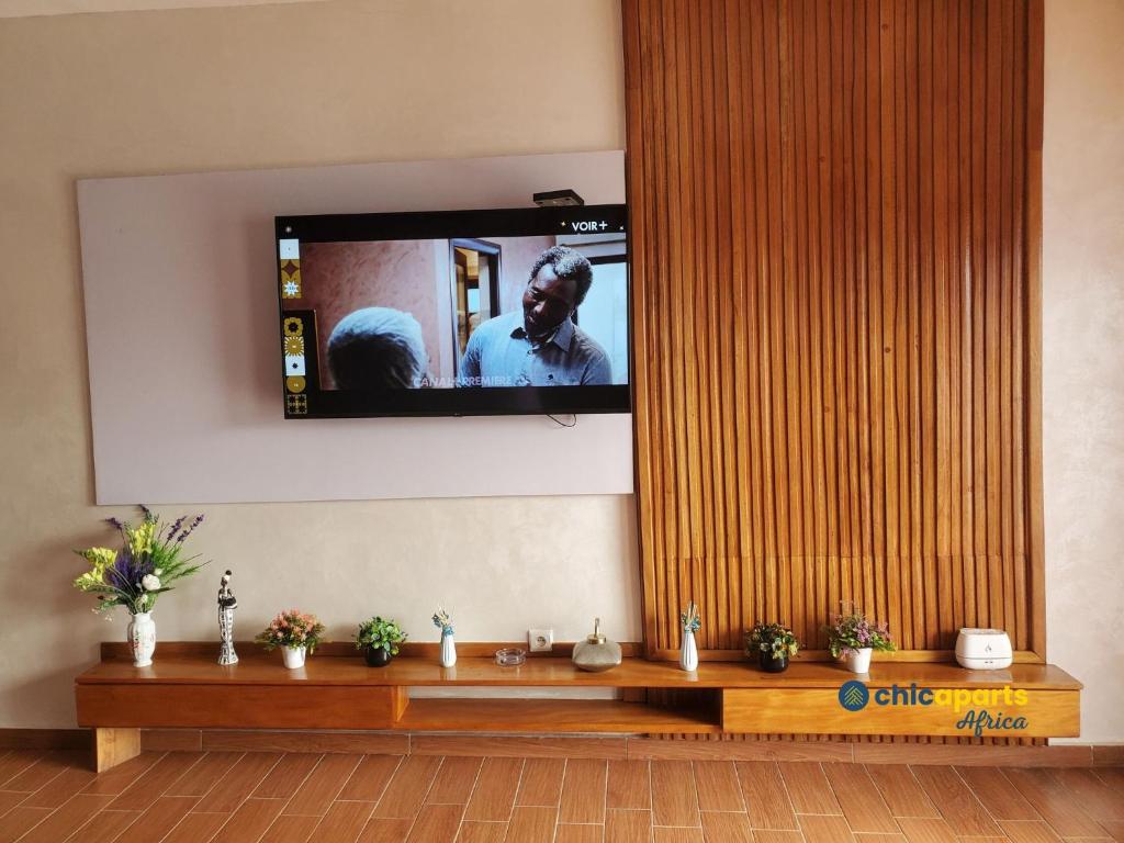 ein Flachbildfernseher, der an einer Wand hängt in der Unterkunft Chic house with pool in Kribi