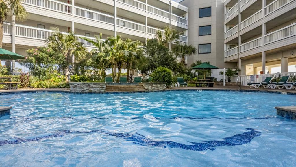 a large pool in the courtyard of a building at Heated Pool Beach View Beachside Haven Balcony in Galveston