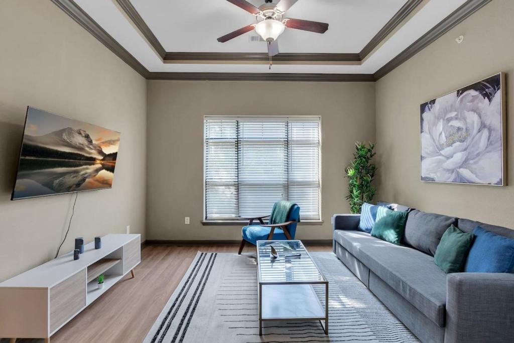 a living room with a couch and a ceiling fan at Chic 2BR- Pool,Gym,Pkng,Near BOK Ctr&Arts Dstrct in Tulsa
