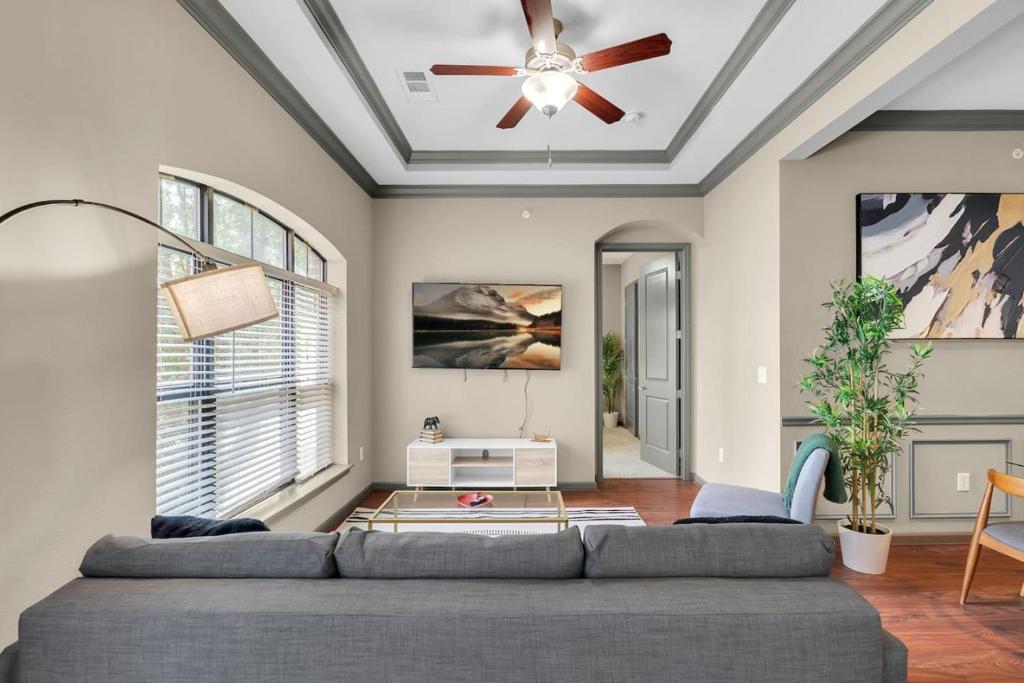 タルサにあるCozy 2BR- Pool,Gym,Pkng,Near BOK Ctr&Arts Dstrctのソファと天井ファンのあるリビングルーム