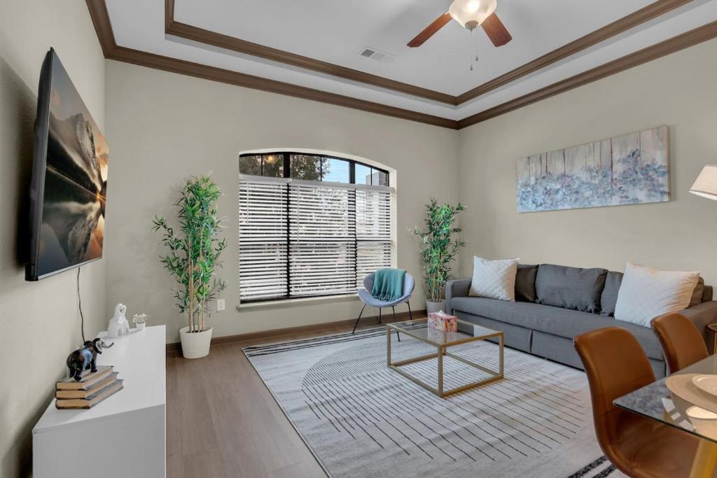 a living room with a couch and a table at Cozy 1BR- Pool,Gym,Pkng,Near BOK Ctr&Arts Dstrct in Tulsa