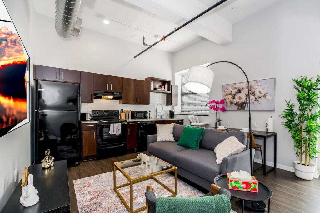 a living room with a couch and a kitchen at Cozy 1BR Parking, Rooftop, Near Arrowhd & TMobile in Kansas City