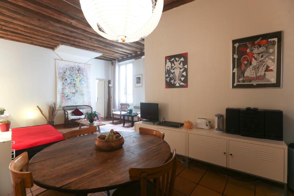 un salon avec une table et un lit dans l'établissement My Trip in Paris - Argout, à Paris