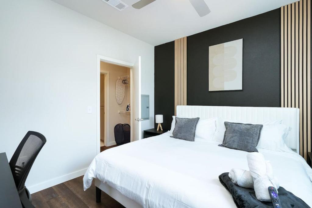1 dormitorio con cama blanca y pared negra en 1BR Escape-w Parking, Near Riverwalk & Conv Ctr, en San Antonio