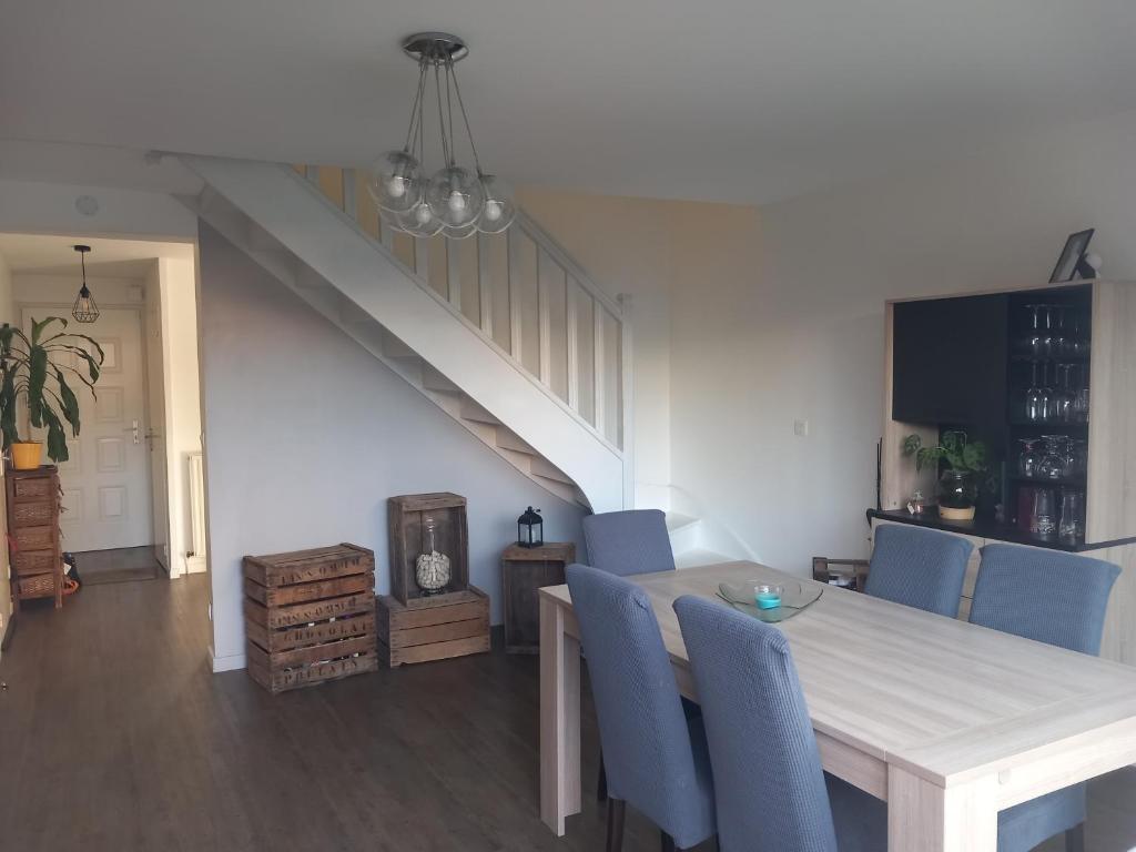 une salle à manger avec une table et des chaises bleues dans l'établissement Maison rénovée proche circuit des 24H, au Mans