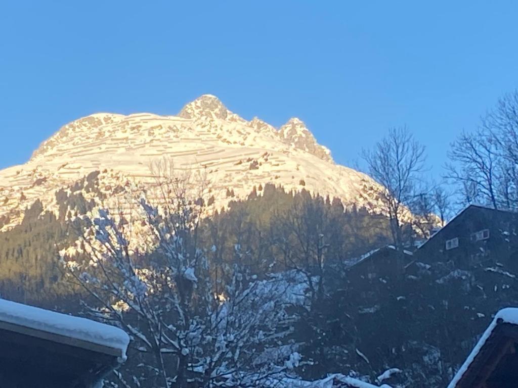 a snow covered mountain in front of a house at Casa Vegana, 3,5 Zi Wohnung, 5 PL, 2 Bäder in Trun