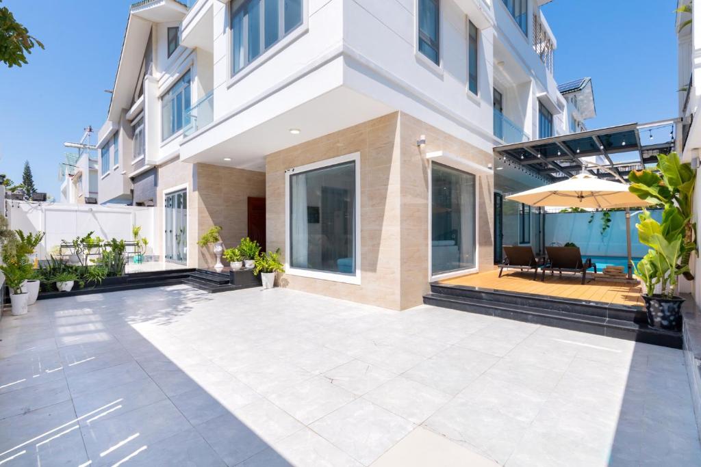 une cour vide d'un bâtiment avec un parasol dans l'établissement B2-11 Hoàng My Villa, à Vung Tau