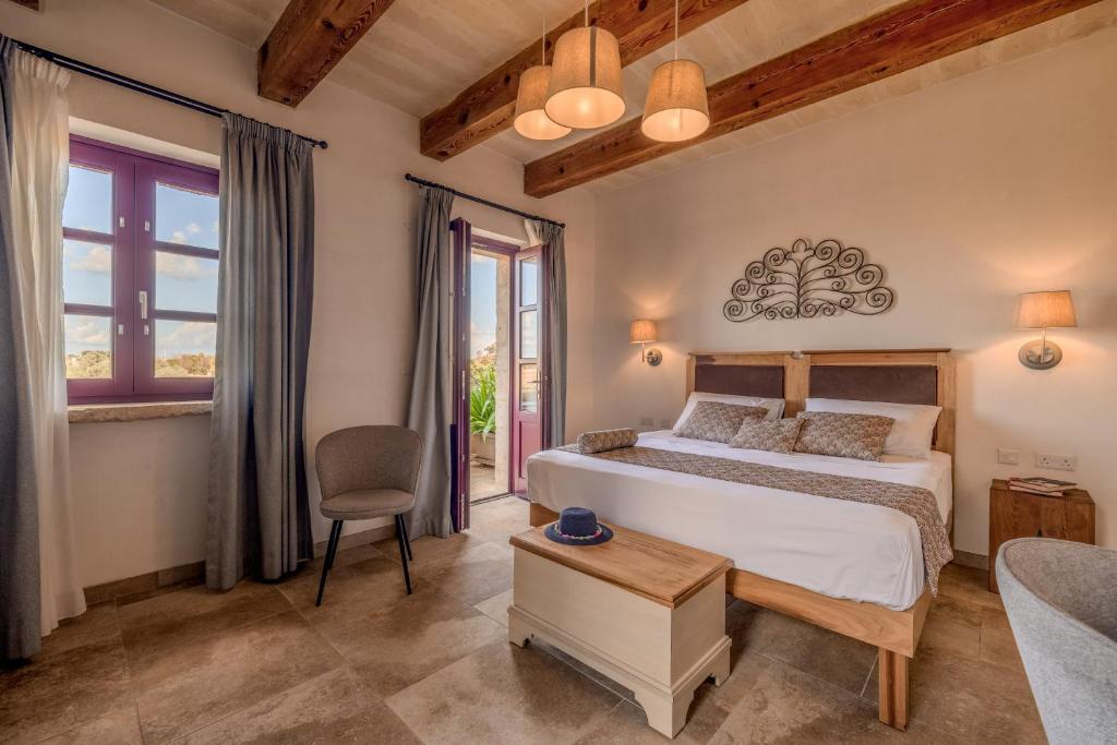een slaapkamer met een bed, een tafel en een stoel bij Mulberries in Żabbar