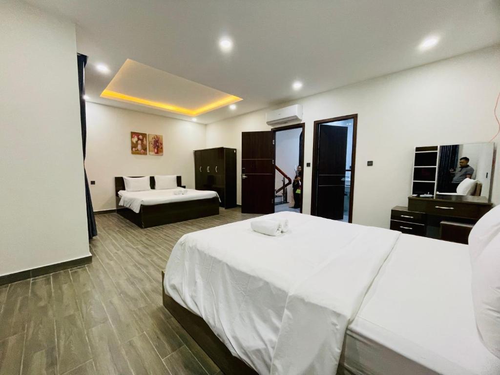 una camera da letto con un grande letto bianco e un divano di Katie Homestay a Phu Quoc