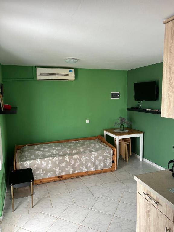sypialnia z łóżkiem i zieloną ścianą w obiekcie Apartmani Starcevic w mieście Vir