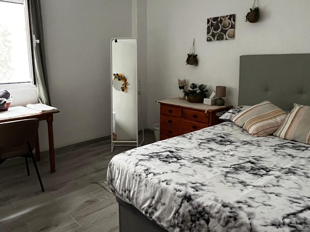 1 dormitorio con cama, escritorio y nevera en Amanecer Isleño Habitaciones, en Arrecife