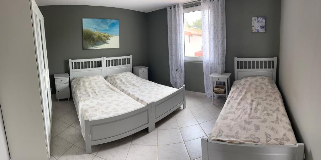 sypialnia z dwoma łóżkami i oknem w obiekcie Apartmani Starcevic w mieście Vir