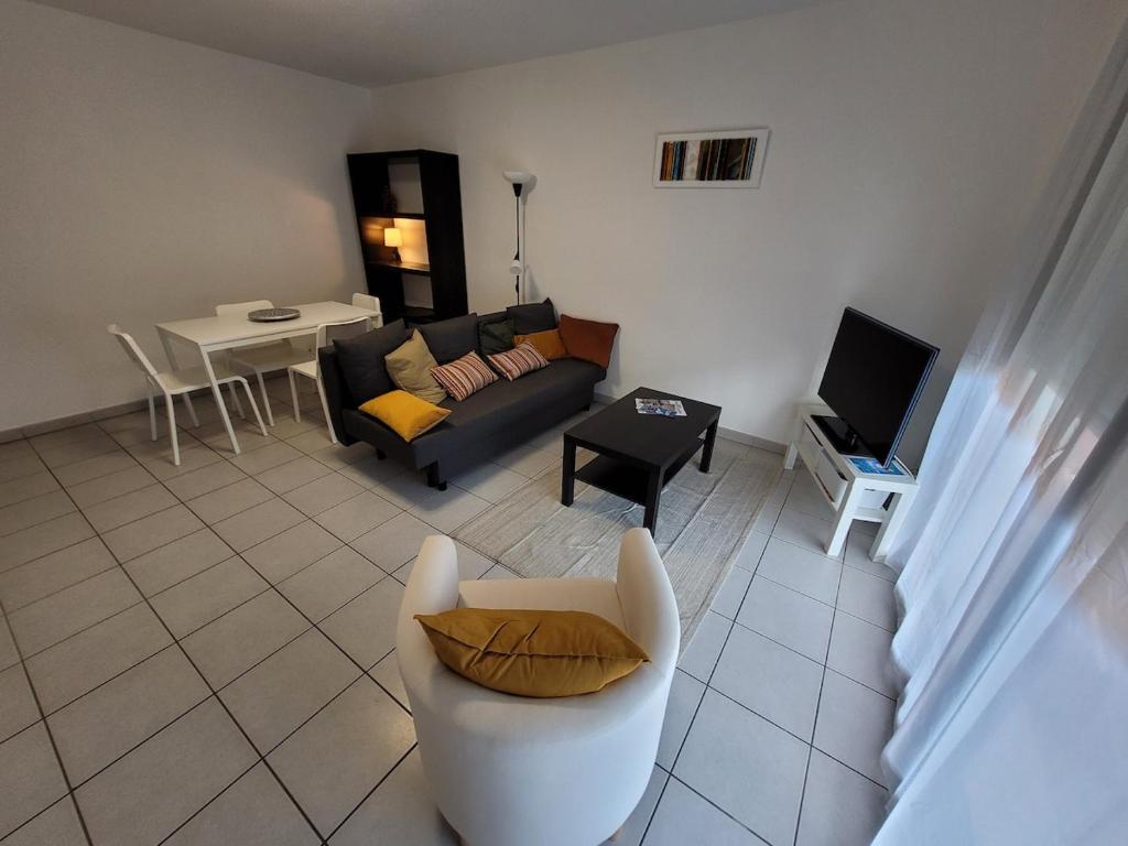 un salon avec un canapé et une table dans l'établissement Entre Médoc et Atlantique, 3 étoiles, calme en plein centre-ville, à Saint-Médard-en-Jalles