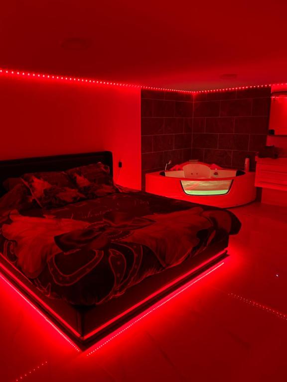 Schlafzimmer mit einem Bett mit roter Lampe in der Unterkunft Love room in Camaret-sur-Aigues