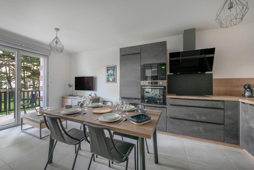 a kitchen with a wooden table and chairs in a kitchen at Appartement pour 4 à 150m de la Mer in Sainte-Marie