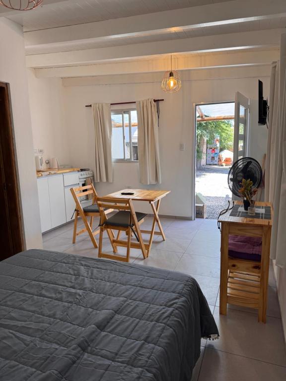Un dormitorio con una cama y una mesa y una cocina. en Monoambiente, en Monte Hermoso
