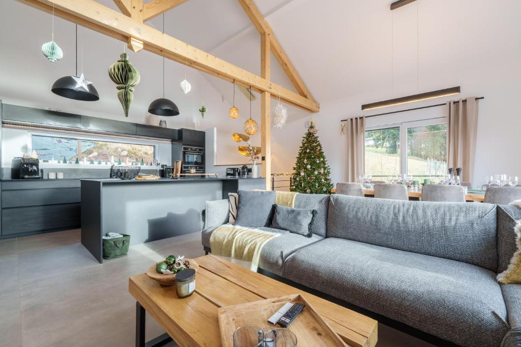 un salon avec un canapé et une table dans l'établissement L’Alma - Magnifique maison avec jacuzzi, à Gérardmer