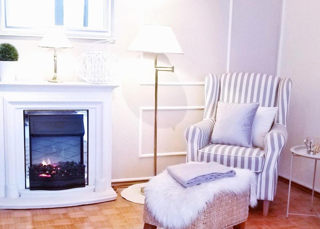 a living room with a chair and a fireplace at Haus Sonneneck 1 in Bad Zwischenahn