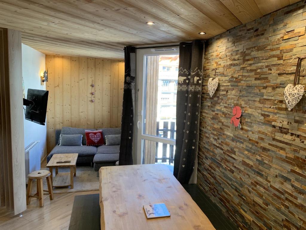 un salon avec un canapé et un mur de briques dans l'établissement Seracs N 33 - 3P6, à Les Deux Alpes