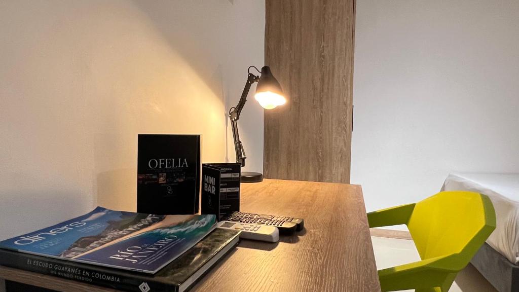a desk with a book and a lamp on it at HOTEL 9.5 SAN FERNANDO in Cali