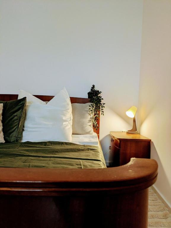 a bed with white pillows and a lamp on a table at Stylish city apartment in Siegen